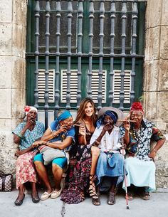 a group of people sitting next to each other in front of a window with bars