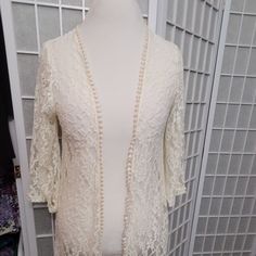 Long Lace Cream Colored Duster Jacket Or Swimsuit Cover Up In Size M By Mauve. About 40 Inches Long From Back Of Neck. Flared 3/4 Sleeves And Scalloped Like Edging. Never Worn. Fitted Cardigan For Brunch, Feminine Fitted V-neck Outerwear, Elegant 3/4 Sleeve Cardigan For Party, Elegant White Outerwear With 3/4 Sleeves, Elegant Summer Cardigan With 3/4 Sleeves, Long Sleeve Outerwear With Lace Trim For Party, Party Outerwear With Lace Trim And Long Sleeves, Fitted Open Front Outerwear For Brunch, Cream Long Sleeve Outerwear With Lace Trim