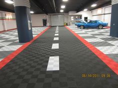 a blue car is parked in a garage with red and white checkered flooring