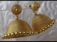 two gold colored earrings with beaded details