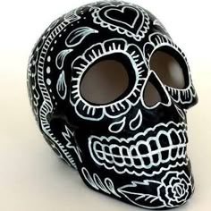 a black and white sugar skull with roses on it's face is seen in this image