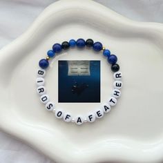 a white plate topped with a blue and black beaded bracelet that reads, brother soaffafata