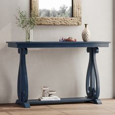 a blue console table with vases on it and a mirror in the corner behind it