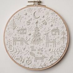 a white embroidered christmas ornament hanging on a wall