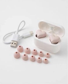 the ear buds are pink in color and have heart shaped plugs attached to them