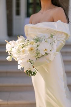 a woman in a white dress holding a bouquet of flowers