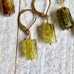 Let your inner Earth Goddess shine through with these lovely green peridot crystals. Simple enough for everyday but also powerful healers and elegant in an earthy, woodsy way. They hang from simple leverback ear wires in your choice of brass or gold fill. Each pair of these 100% natural stones are unique and ready to gift to that someone special. *The color ranges in these natural stones but all fall pretty close to the colors in the photos. Choose which color suits you best from the drop down m Peridot Dangle Earrings, Inner Earth, Raw Crystal Earrings, 16th Wedding Anniversary, Raw Peridot, Earth Goddess, Peridot Crystal, Peridot Jewelry, Peridot Earrings