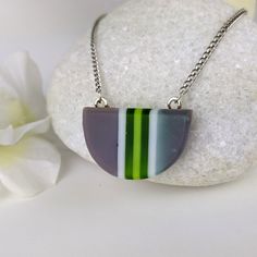 One of a kind handmade fused glass pendant. Simple and elegant modern minimalist style Transparent green gray and with stripes with geometric shape. Size: 30mm x 20mm x 6mm. Cast silver necklace attachments. Incorporates Bullseye opal and transparent glass. Sculpted by hand and fused multiple times. Includes nickle free hypoallergenic 18 inch attached chain. Message anytime with questions. -Sean Modern Green Necklace As Gift, Modern Green Necklace For Gift, Modern Green Necklace As A Gift, Modern Green Necklace With Round Pendant, Modern Green Round Pendant Necklace, Minimalist Green Jewelry With Recycled Glass, Minimalist Green Glass Jewelry, Modern Green Geometric Jewelry, Silver Faceted Glass Necklace