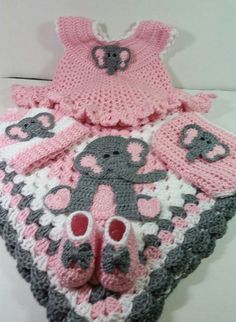 a crocheted baby blanket with pink and gray elephants on it