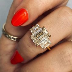 a woman's hand with an orange manicured nail and ring on her finger