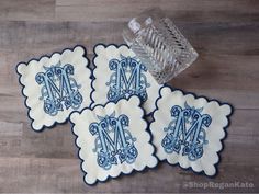 blue and white monogrammed coasters with the letter m on them sitting on a wood floor