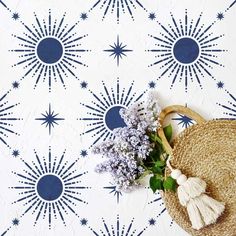 a straw hat and some flowers on a white background with blue sunbursts