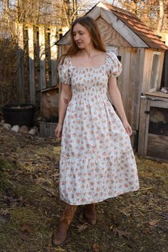 Gray Scroll Rose Bunches Floral Cotton Prairie Dress, Smocked Bodice, Puffed Sleeves, Midi Length, with Pockets Product Details: Embrace understated elegance with our Gray Scroll Rose Bunches Floral Cotton Prairie Dress. This sophisticated dress features a soft white backdrop adorned with delicate silver swirls and soft pink roses, creating a subtle yet enchanting pattern. The smocked bodice offers a comfortable, adjustable fit, while the puffed sleeves and flowy midi skirt enhance the classic prairie silhouette. Practical side pockets add a modern touch to this timeless design. Ideal for a variety of occasions, from casual gatherings to elegant events, this dress pairs beautifully with sandals or boots. Layer with a cardigan or jacket to transition seamlessly through the seasons. Key Feat Luxury Elegant Prairie Dress For Spring, Luxury Fitted Prairie Dress For Women, Luxury Elegant Prairie Dress, Luxury Fitted Romantic Prairie Dress, Luxury Fitted Elegant Prairie Dress, Prairie Dress Modern Casual, Soft Pink Roses, Prairie Dresses, Dress Drawing