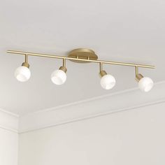 three lights are hanging from the ceiling in a room with white walls and wood flooring