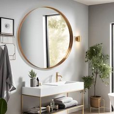 a bathroom with a sink, mirror and bathtub next to a potted plant