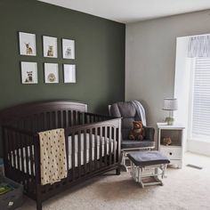 a baby's room with green walls and pictures on the wall