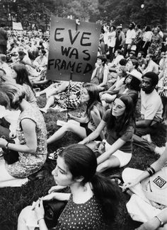 a group of people sitting on the ground with signs in front of them that say eve was framed