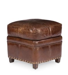 a brown leather ottoman with studded legs