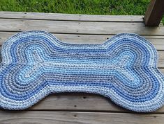 a blue and white dog bone rug on a wooden deck