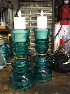 two teal glass candlesticks sitting on top of a wooden table