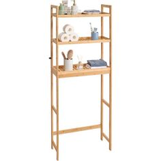 three tier bamboo shelf with towels and other items on the top shelves, isolated against a white background