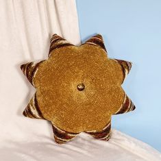 a brown and white pillow sitting on top of a bed next to a blue wall