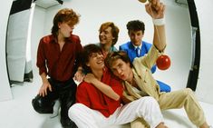 a group of young men posing for a photo in front of a white background with an orange ball