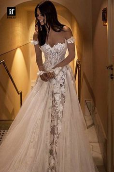 a woman in a wedding dress standing on stairs