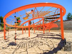 an orange playground structure with two people on the top and one person in the middle