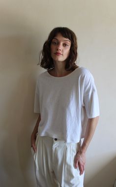 The Lenny Hemp Jersey Cropped Tee is a staple from Na Nin that combines the comfortable and worn-in texture of a vintage t-shirt with the unique texture of hemp. With a simple yet sophisticated staple, adapted to suit our coveted high-waist styles. This uncomplicated version shares the beautiful relaxed ease essential for one's wardrobe. Made in USA Conscious White Crew Neck Top, White Crew Neck Top, White Conscious Crew Neck Top, Linen Crew Neck Top For Layering, Crew Neck Linen Tops For Layering, Everyday Linen Tops With Shirttail Hem, Relaxed Linen Tops For Casual Gatherings, Oversized Linen Tops For Everyday, Everyday Conscious Style Crew Neck Tops