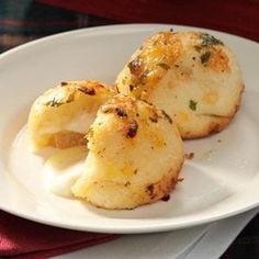 two scallops are on a white plate