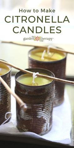 three jars filled with candles sitting on top of a white cloth covered table next to bamboo sticks