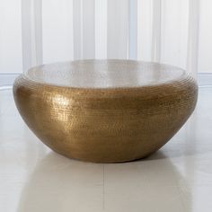 a large golden bowl sitting on top of a white floor