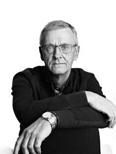 black and white photo of an older man with his arms crossed looking at the camera