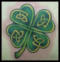 a shamrock tattoo on the back of a man's shoulder