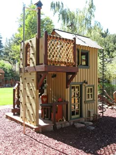 a small wooden structure with a play set in the background