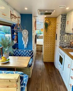 the interior of a camper with blue and white decor on the walls, wood flooring