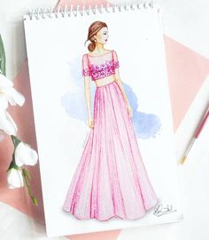 a drawing of a woman in a pink dress on top of a notepad next to flowers