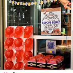 there is a display in the window with red cups on it and an advertisement for rescue squad