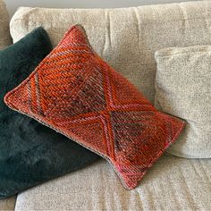 two pillows sitting on top of a couch next to each other