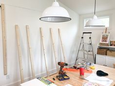 a table with tools on it and some lights hanging from the ceiling in front of it