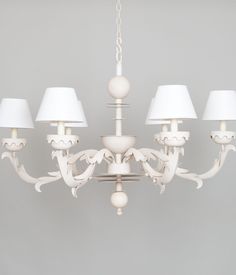 a white chandelier with five lamps hanging from it