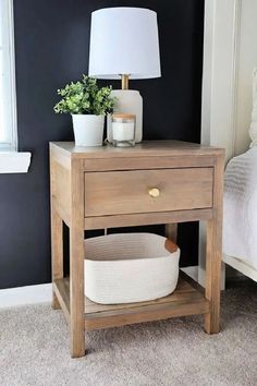 a nightstand with a basket underneath it and a lamp next to it on the side