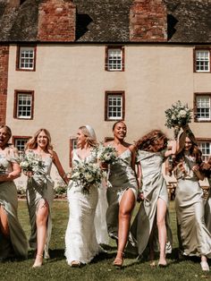 a group of bridesmaids walking in front of a building