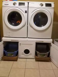 two washers are stacked on top of each other in front of the dryer