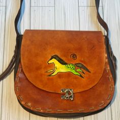 a brown purse with a horse painted on it