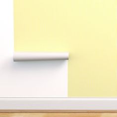 an empty room with yellow wallpaper and a white rolled up piece of paper on the wall