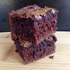 two pieces of brownie sitting on top of a wooden table next to each other