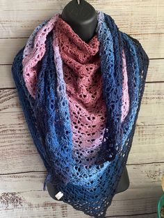 a blue, pink and purple crocheted shawl on a mannequin