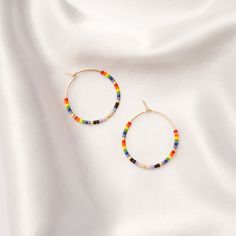 Show off your artsy side with our Seed Bead Classic Hoops. Fun and colorful, these hoops are available in two sizes and five color combination options. Choose the calming colors of the ocean, the neutral tones of the desert, the bright colors of mosaic, the neutral colors of maple or the array of colors in the rainbow. The hoops are 14k gold filled and pair beautifully with our glass Seed Bead Necklace. Colors In The Rainbow, Glass Seed Bead Necklace, Calming Colors, Seed Bead Necklace, Neutral Tones, The Desert, Color Combination, The Rainbow, Bead Necklace